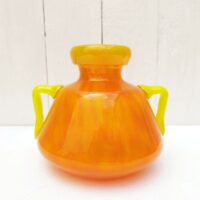 Vase à anse en verre soufflé, dans des tons très acidulés orange et jaune. Décor marmoréen. Signé à la pointe sur le bas, datant des années 20. Excellent état. Hauteur : 14 cm Diamètre  : 12,8 cm