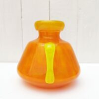 Vase à anse en verre soufflé, dans des tons très acidulés orange et jaune. Décor marmoréen. Signé à la pointe sur le bas, datant des années 20. Excellent état. Hauteur : 14 cm Diamètre  : 12,8 cm