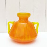 Vase à anse en verre soufflé, dans des tons très acidulés orange et jaune. Décor marmoréen. Signé à la pointe sur le bas, datant des années 20. Excellent état. Hauteur : 14 cm Diamètre  : 12,8 cm