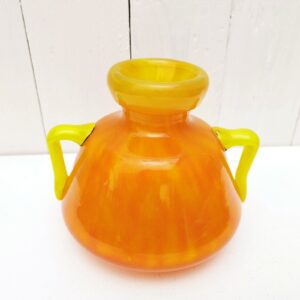 Vase à anse en verre soufflé, dans des tons très acidulés orange et jaune. Décor marmoréen. Signé à la pointe sur le bas, datant des années 20. Excellent état. Hauteur : 14 cm Diamètre  : 12,8 cm