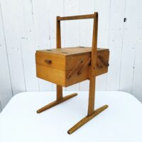 Ancienne boîte à couture dépliante en bois datant des années 60. Petites traces et rayures d'usage. Du tissu a été mis sur l'intérieur  bon état général. Hauteur : 49,5 cm Longueur dépliée : 75,5 cm