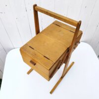 Ancienne boîte à couture dépliante en bois datant des années 60. Petites traces et rayures d'usage. Du tissu a été mis sur l'intérieur  bon état général. Hauteur : 49,5 cm Longueur dépliée : 75,5 cm