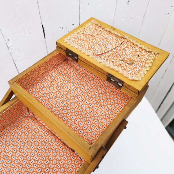 Ancienne boîte à couture dépliante en bois datant des années 60. Petites traces et rayures d'usage. Du tissu a été mis sur l'intérieur  bon état général. Hauteur : 49,5 cm Longueur dépliée : 75,5 cm