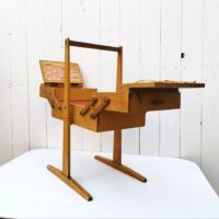 Ancienne boîte à couture dépliante en bois datant des années 60. Petites traces et rayures d'usage. Du tissu a été mis sur l'intérieur  bon état général. Hauteur : 49,5 cm Longueur dépliée : 75,5 cm
