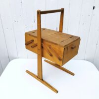 Ancienne boîte à couture dépliante en bois datant des années 60. Petites traces et rayures d'usage. Du tissu a été mis sur l'intérieur  bon état général. Hauteur : 49,5 cm Longueur dépliée : 75,5 cm