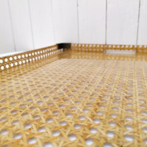 Grand plateau de service en cannage recouvert de lucite ( plexiglas épais) , avec encoignure en laiton. Créé par Gabriella Crespi pour la maison Dior dans les années 70. Traces et rayures d'usage. Très bon état. Dimensions : 56,5 x 41,5 x 3 cm