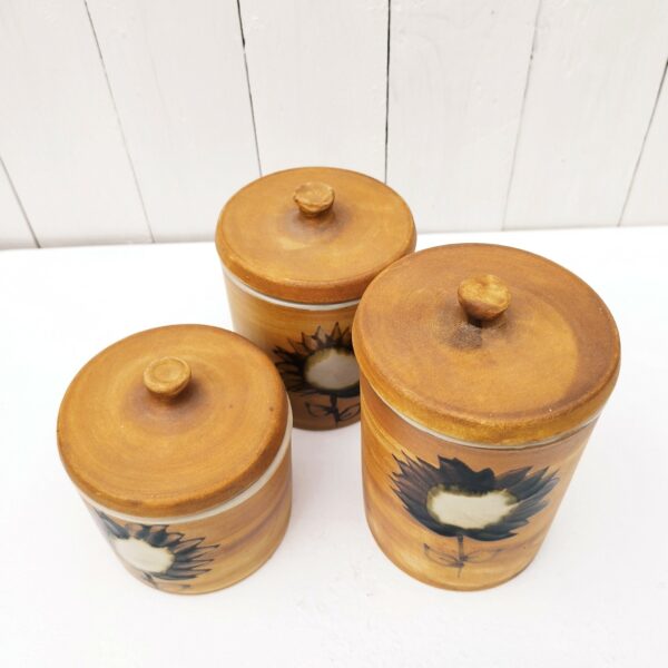 Trois pots à épices au autre de la poterie La colombe à Orriule prés de Vallauris. Créée par Madeleine Brault. Décor de fleur émaillé. Excellent état. Hauteurs sans couvercle : 8,5 cm-11,5 cm-14,5 cm Diamètres : 10,5 cm