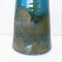 Vase en grès vernissé et émaillé. Des teintes de bleues  Signé Pierre Pigaglio. Excellent état. Hauteur : 24 cm Diamètre : 7,5 cm