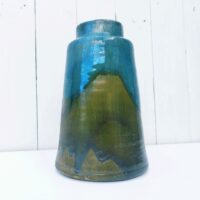 Vase en grès vernissé et émaillé. Des teintes de bleues  Signé Pierre Pigaglio. Excellent état. Hauteur : 24 cm Diamètre : 7,5 cm