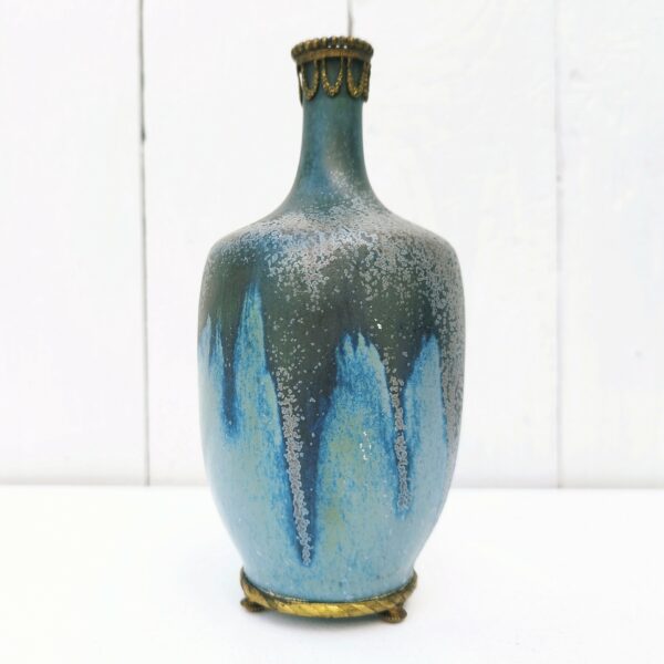 Vase soliflore en grès flammé serti d'une garniture en bronze au col et sur le dessous dans les tons bleus. Non signé Excellent état. Hauteur : 15,5  cm