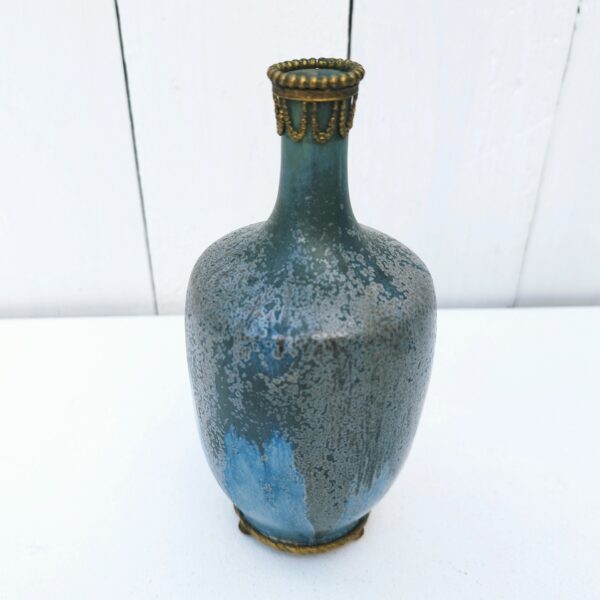 Vase soliflore en grès flammé serti d'une garniture en bronze au col et sur le dessous dans les tons bleus. Non signé Excellent état. Hauteur : 15,5  cm
