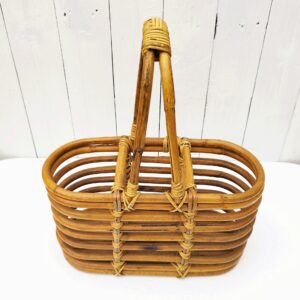 Porte bouteilles en rotin, comprenant trois compartiments. Idéal pour un pique-nique chic et tendance Petites usures des liens sans gravité, des petites taches. Très bon état Hauteur : 37 cm Dimension casiers : 31,5 x 14 x 18,5 cm