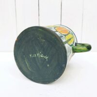Vase ou pot à anse en céramique, à décor de feuilles colorées jaunes et orange. Un micro éclat sur le dessous, non visible une fois posé.  Très bon état.  Hauteur : 16 cm Diamètre : 12, 5 cm