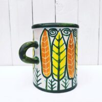 Vase ou pot à anse en céramique, à décor de feuilles colorées jaunes et orange. Un micro éclat sur le dessous, non visible une fois posé.  Très bon état.  Hauteur : 16 cm Diamètre : 12, 5 cm