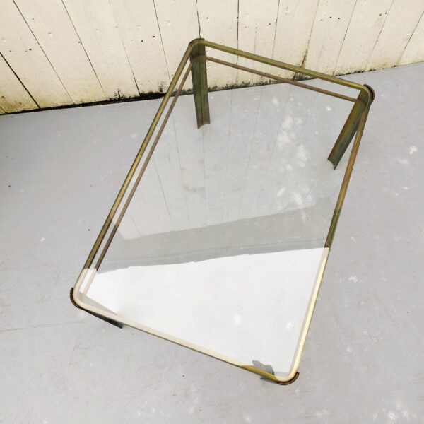 Table basse, piétement en bronze doré, tablette en verre épais. De la maison Malabert attribuée à Jacques Quinet. Datant des années 60. Table signée et numérotée. Bon état général. Dimensions : 60 x 40 x 35,5 cm