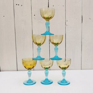 Six verres à porto anciens George Sand en verre de couleur ocre et pied bleu turquoise. Très bon état. Hauteur : 11 cm Diamètre : 6 cm