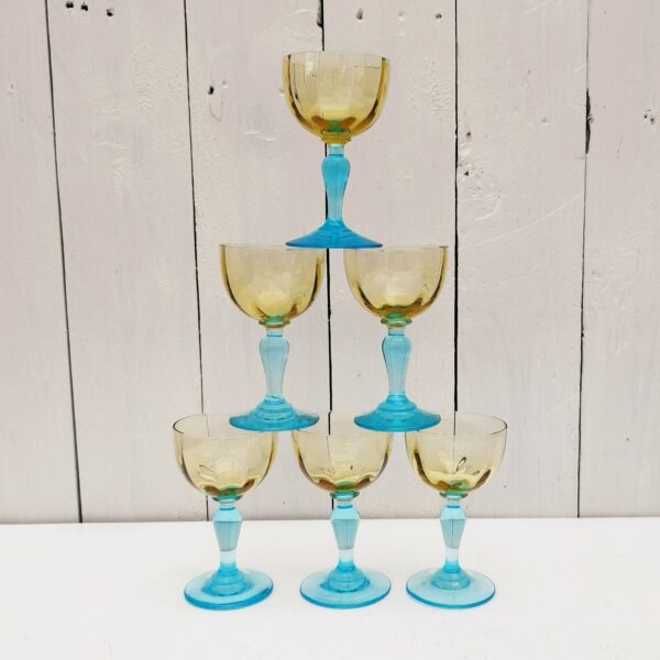 Six verres à porto anciens George Sand en verre de couleur ocre et pied bleu turquoise. Un féle sur le haut d'un verre.  Bon état. Hauteur : 11 cm Diamètre : 6 cm