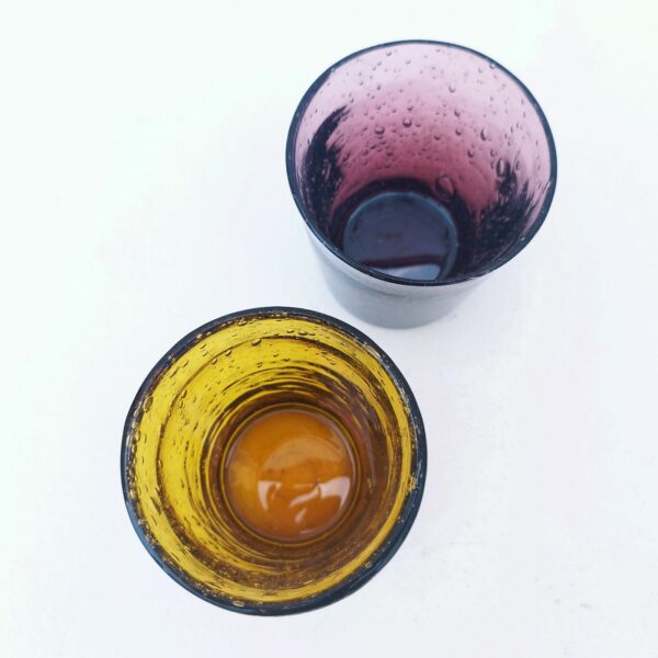 Deux verres à whisky en verre soufflé de la verrerie de Biot. Les bulles dans le verre sont typiques de cette manufacture. L'un ambré et l'autre dans les tons prunes De très belle facture, ils sont assez lourd Très bon état. Hauteur : 10 cm Diamètre 8,5 cm