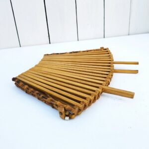 Corbeille à fruits pliante en lamelles de bois et poignée en bambou, datant des années 60. rayures et traces d'usage.  Fil de fer de maintien coupé et présent à la base de l'anse mais n'altérant pas sa structure Bon état général. Longueur dépliée : 31 cm Largeur : 26,5 cm