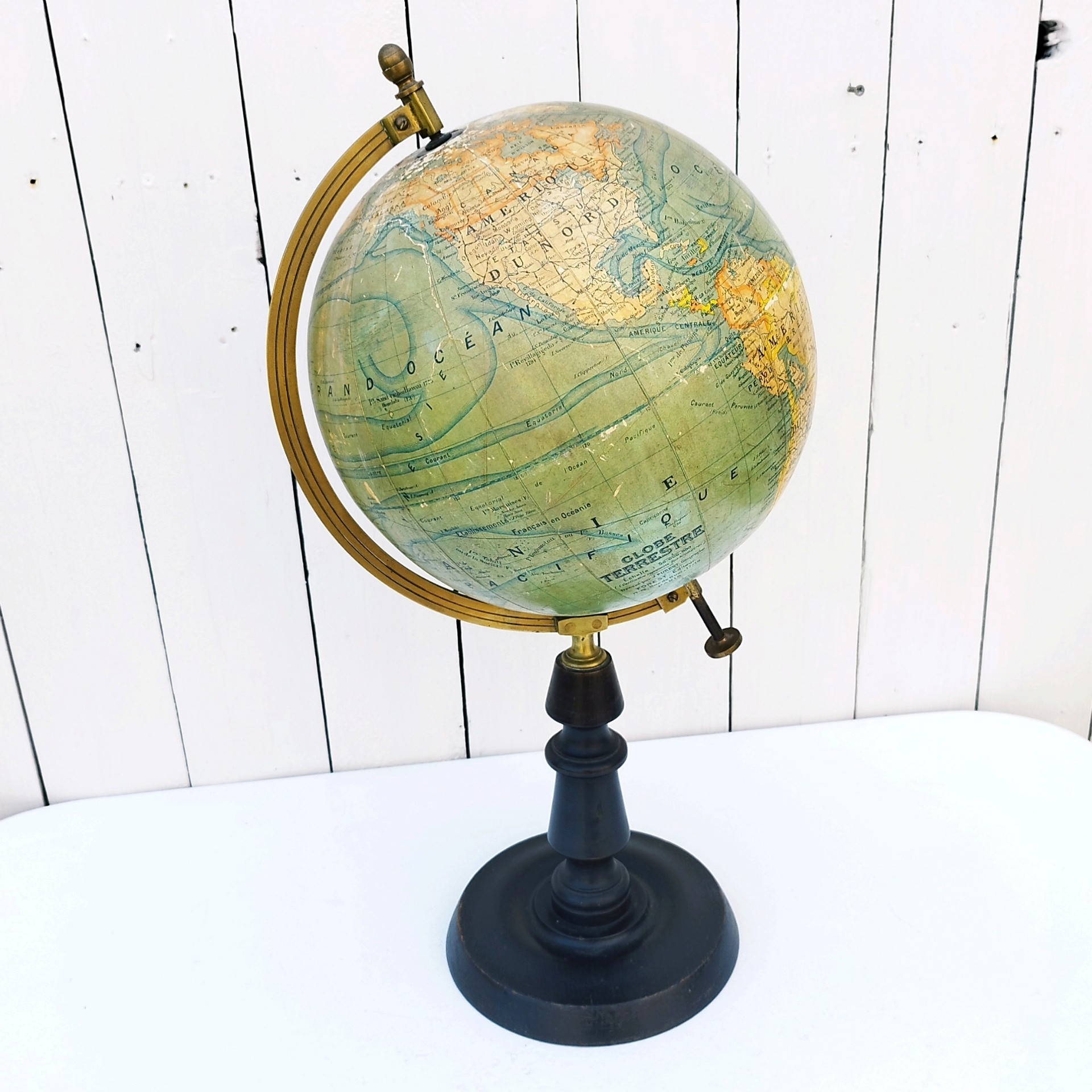 Grand globe Napoléon III en carton recouvert de la carte du monde en papier, pivotant sur un pied en bois noirci , entouré d'une réglette en laiton crée par J.Forest et édité par lui même. Usure du papier sur le dessus du globe, quelques petits manques de papier. Bon état général. Hauteur : 50 cm Diamètre : ~23 cm