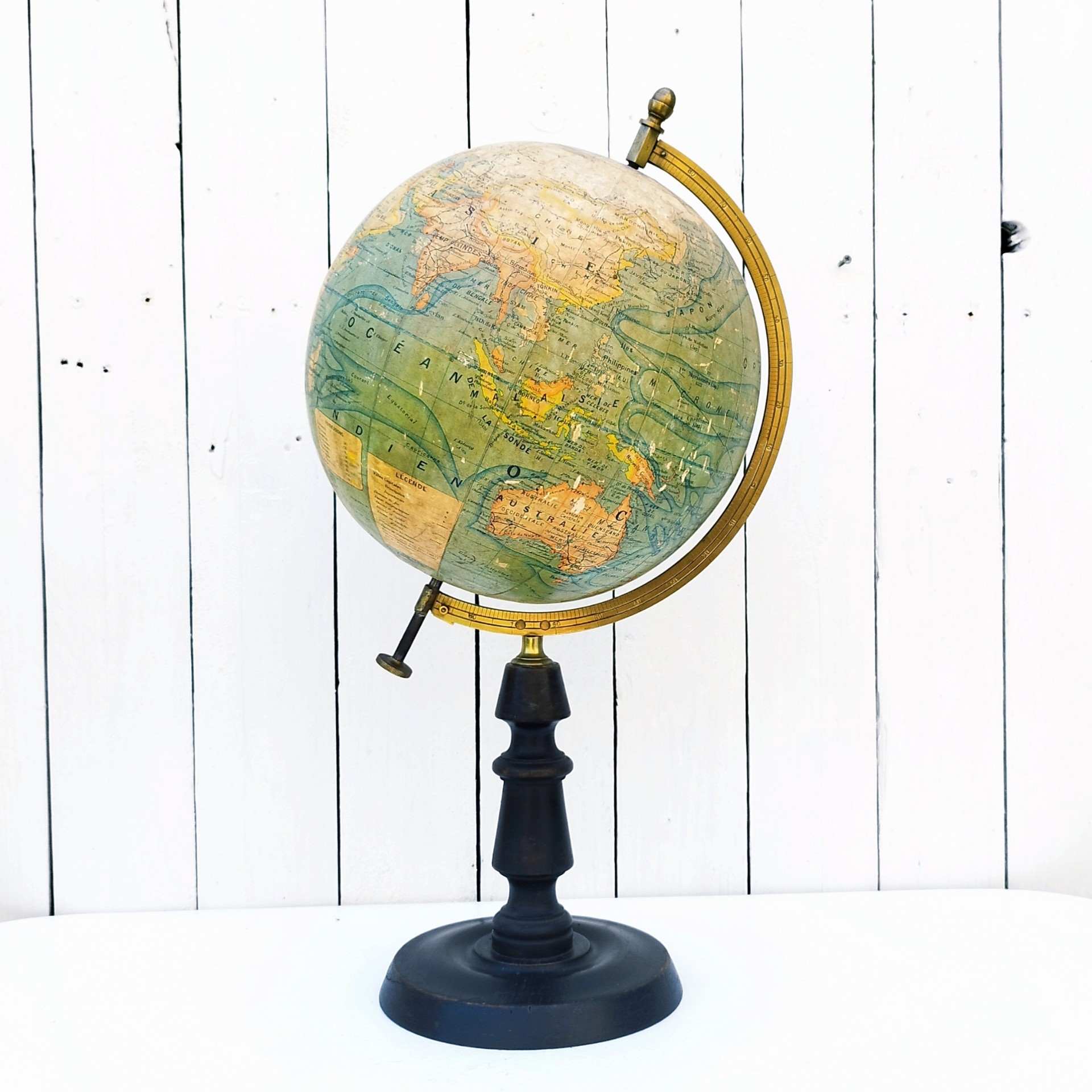 Grand globe Napoléon III en carton recouvert de la carte du monde en papier, pivotant sur un pied en bois noirci , entouré d'une réglette en laiton crée par J.Forest et édité par lui même. Usure du papier sur le dessus du globe, quelques petits manques de papier. Bon état général. Hauteur : 50 cm Diamètre : ~23 cm