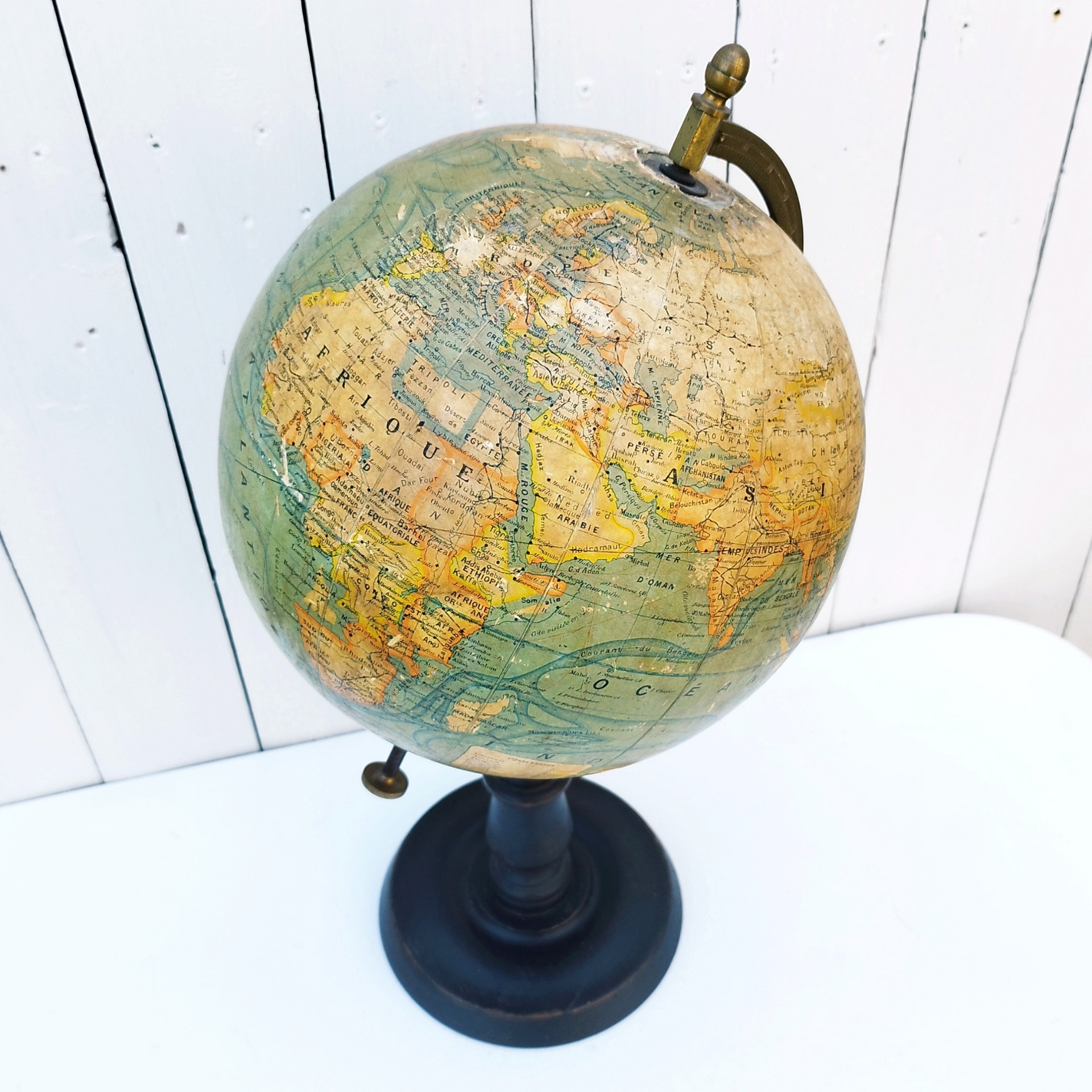 Grand globe Napoléon III en carton recouvert de la carte du monde en papier, pivotant sur un pied en bois noirci , entouré d'une réglette en laiton crée par J.Forest et édité par lui même. Usure du papier sur le dessus du globe, quelques petits manques de papier. Bon état général. Hauteur : 50 cm Diamètre : ~23 cm