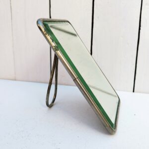 Miroir de barbier simple, structure en métal à poser ou suspendre. Miroir épais biseauté. Quelques rayures sur les miroirs. Traces de corrosion sans gravité . Un petit féle dans un coin.  Bon état général Dimensions : 13,5 x 18 cm