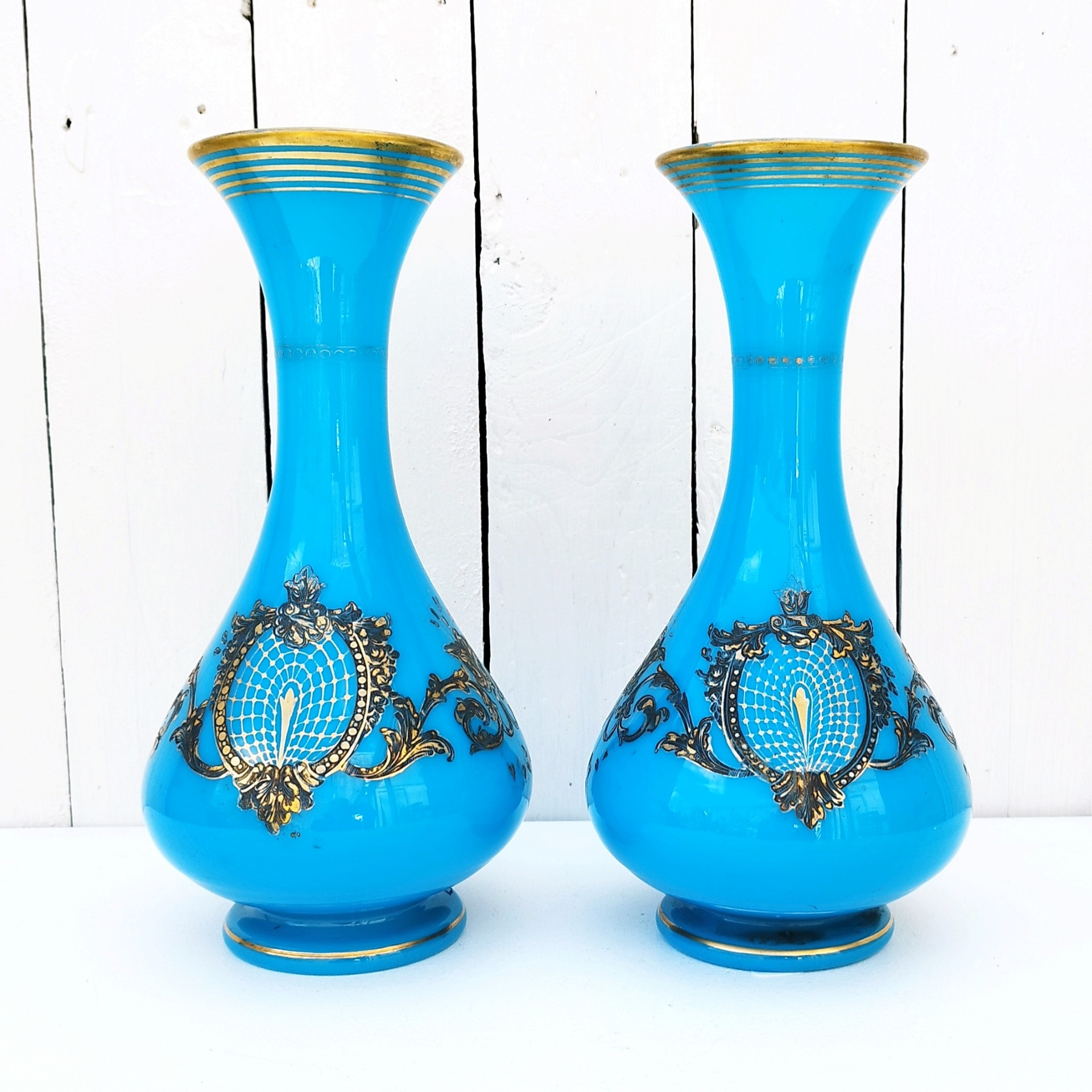 Paire de vase piédouche en opaline bleue turquoise et décor doré de la cristallerie de Baccarat. Epoque Napoléon III. Des petits manques de dorures dans le décor et aux cols. Bon état général Hauteur : 28,5 cm