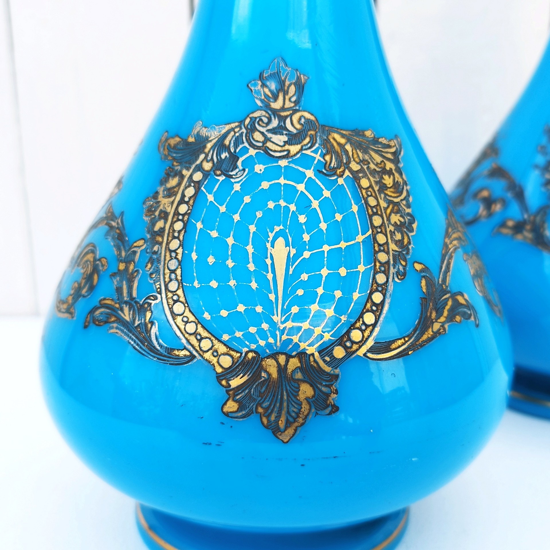 Paire de vase piédouche en opaline bleue turquoise et décor doré de la cristallerie de Baccarat. Epoque Napoléon III. Des petits manques de dorures dans le décor et aux cols. Bon état général Hauteur : 28,5 cm