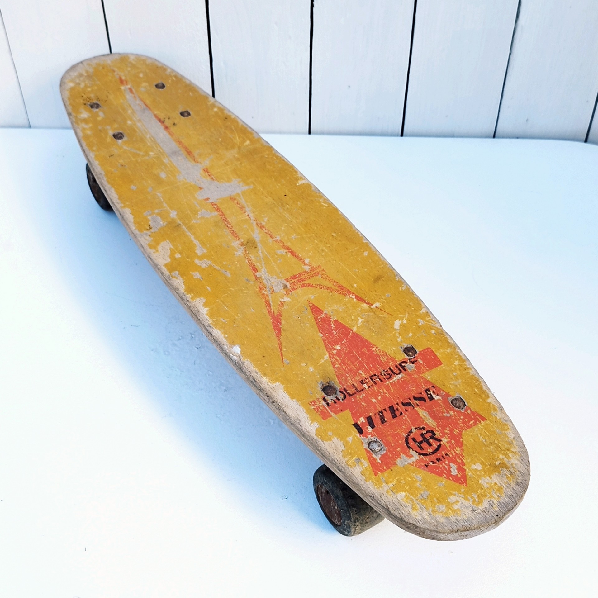 Ancien skate board ou roller surf en bois de la marque CHR vitesse Paris. Possède ses quatre roues, Il est roulant (mériterait un peu de graisse). Traces d'usage, manque de peinture, des chocs. Il a servi. Etat d'usage Longueur : 57,5 cm Largeur max : 14,5 cm