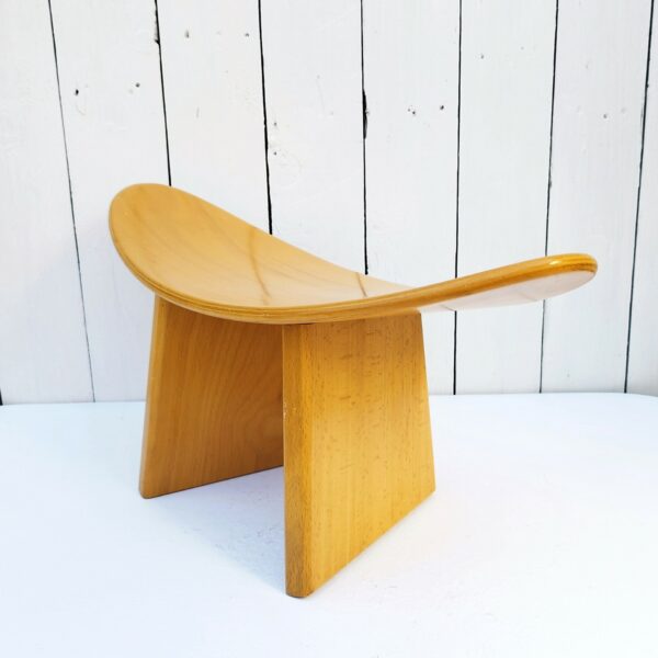 Tabouret vintage shoggi en bois couleur naturel signé Alain Gaubert. Un des pieds a été collé et ne se démonte pas alors que l'autre s'enlève. Petites rayures et traces d'usage sur l'assise et les pieds  Bon état. Hauteur : 19 cm Longueur : 47 cm Largeur : 20 cm