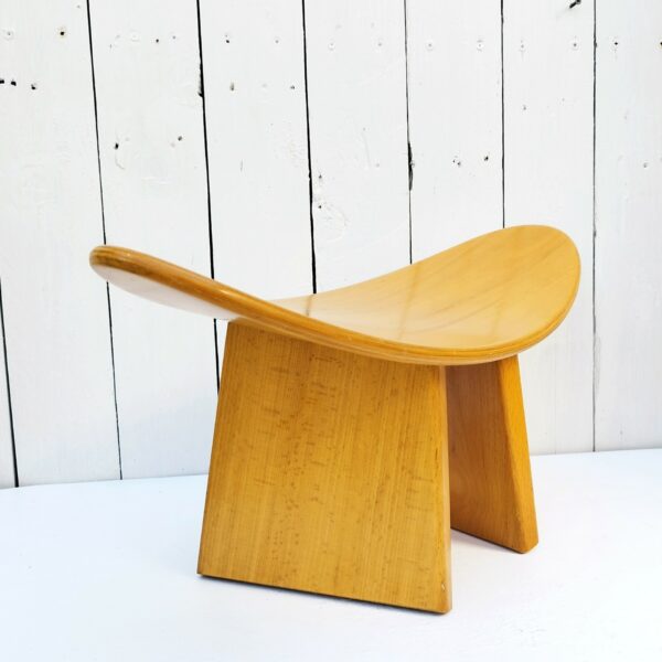 Tabouret vintage shoggi en bois couleur naturel signé Alain Gaubert. Un des pieds a été collé et ne se démonte pas alors que l'autre s'enlève. Petites rayures et traces d'usage sur l'assise et les pieds  Bon état. Hauteur : 19 cm Longueur : 47 cm Largeur : 20 cm