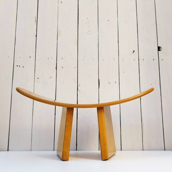 Tabouret vintage shoggi en bois couleur naturel signé Alain Gaubert. Un des pieds a été collé et ne se démonte pas alors que l'autre s'enlève. Petites rayures et traces d'usage sur l'assise et les pieds  Bon état. Hauteur : 19 cm Longueur : 47 cm Largeur : 20 cm