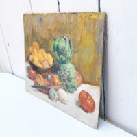 Nature morte représentant des légumes dans une corbeille et sur une table. On peut y voir des tomates, citrons,oignons et deux artichauts qui sont le sujet principal de cette peinture. Au centre un couteau d'office prêt à la découpe Peinture sur carton non signée, très belle maîtrise du sujet et de la technique. Petites rayures d'usage. Bon état général Dimensions : 24 x 19 cm