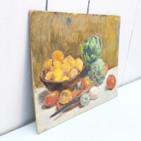 Nature morte représentant des légumes dans une corbeille et sur une table. On peut y voir des tomates, citrons,oignons et deux artichauts qui sont le sujet principal de cette peinture. Au centre un couteau d'office prêt à la découpe Peinture sur carton non signée, très belle maîtrise du sujet et de la technique. Petites rayures d'usage. Bon état général Dimensions : 24 x 19 cm