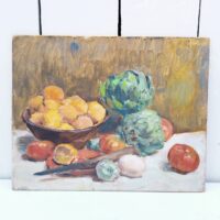 Nature morte représentant des légumes dans une corbeille et sur une table. On peut y voir des tomates, citrons,oignons et deux artichauts qui sont le sujet principal de cette peinture. Au centre un couteau d'office prêt à la découpe Peinture sur carton non signée, très belle maîtrise du sujet et de la technique. Petites rayures d'usage. Bon état général Dimensions : 24 x 19 cm