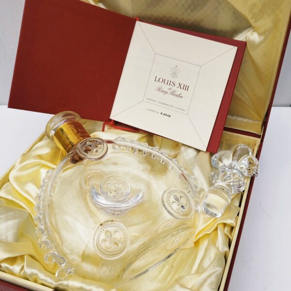 Belle bouteille de cognac en cristal de Baccarat créée par Remy Martin modèle Louis XIII , rehaussé de cabochons fleurs de lys, Bouchon fleur de lys, signé et numéroté. Coffret d'origine. Bouteille signée et numérotés. Très beau cadeau pour un amateur de cognac. Très bon état. Hauteur bouteille sans bouchon : 19 cm Dimensions coffret : 27 x 27 x  9,5 cm