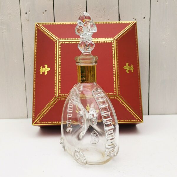 Belle bouteille de cognac en cristal de Baccarat créée par Remy Martin modèle Louis XIII , rehaussé de cabochons fleurs de lys, Bouchon fleur de lys, signé et numéroté. Coffret d'origine. Bouteille signée et numérotés. Très beau cadeau pour un amateur de cognac. Très bon état. Hauteur bouteille sans bouchon : 19 cm Dimensions coffret : 27 x 27 x  9,5 cm