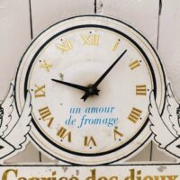 Rare pendule publicitaire pour la marque de fromages Caprice des dieux.  Pendule entourée de deux anges marqué Caprice de Dieux en lettres dorées. Des manques de peintures, des rayures et chocs d'usage. Le mécanisme de la pile est à changer car ne fonctionne pas (facilement trouvable sur internet ou magasin de bricolage) Etat d'usage. Dimensions : 41,5  x 27 cm