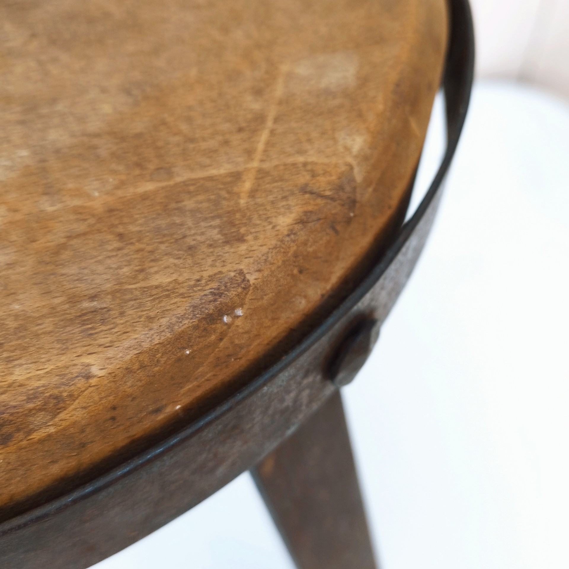 Petit tabouret brutaliste avec assise en bois patiné, cerclage  et pieds en fer forgé. Décoration très campagne ou très Loft. Patine d'origine. Un boulon a été changé. Bon état général. Hauteur : 38 cm Diamètre : 27 cm