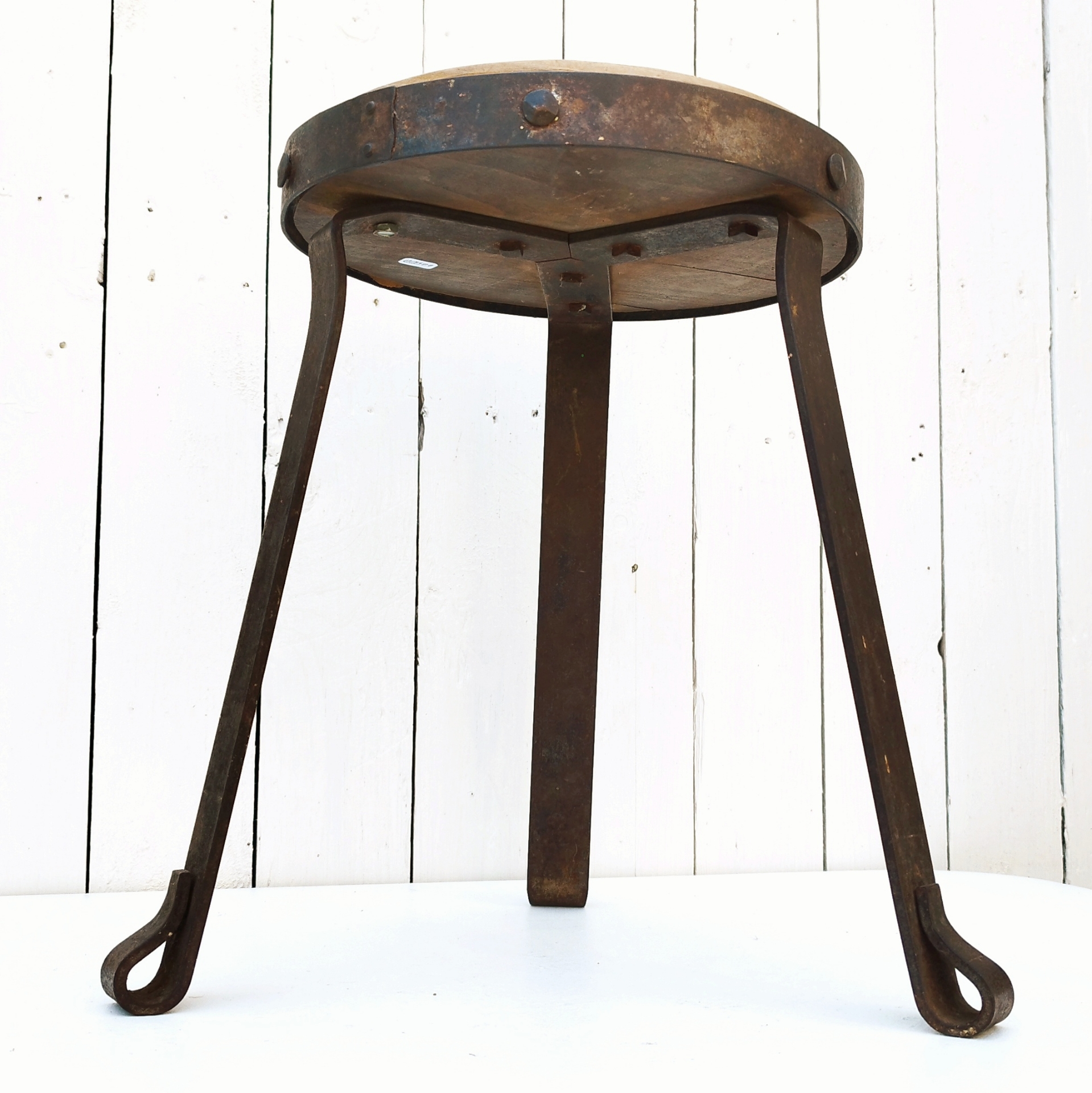Petit tabouret brutaliste avec assise en bois patiné, cerclage  et pieds en fer forgé. Décoration très campagne ou très Loft. Patine d'origine. Un boulon a été changé. Bon état général. Hauteur : 38 cm Diamètre : 27 cm