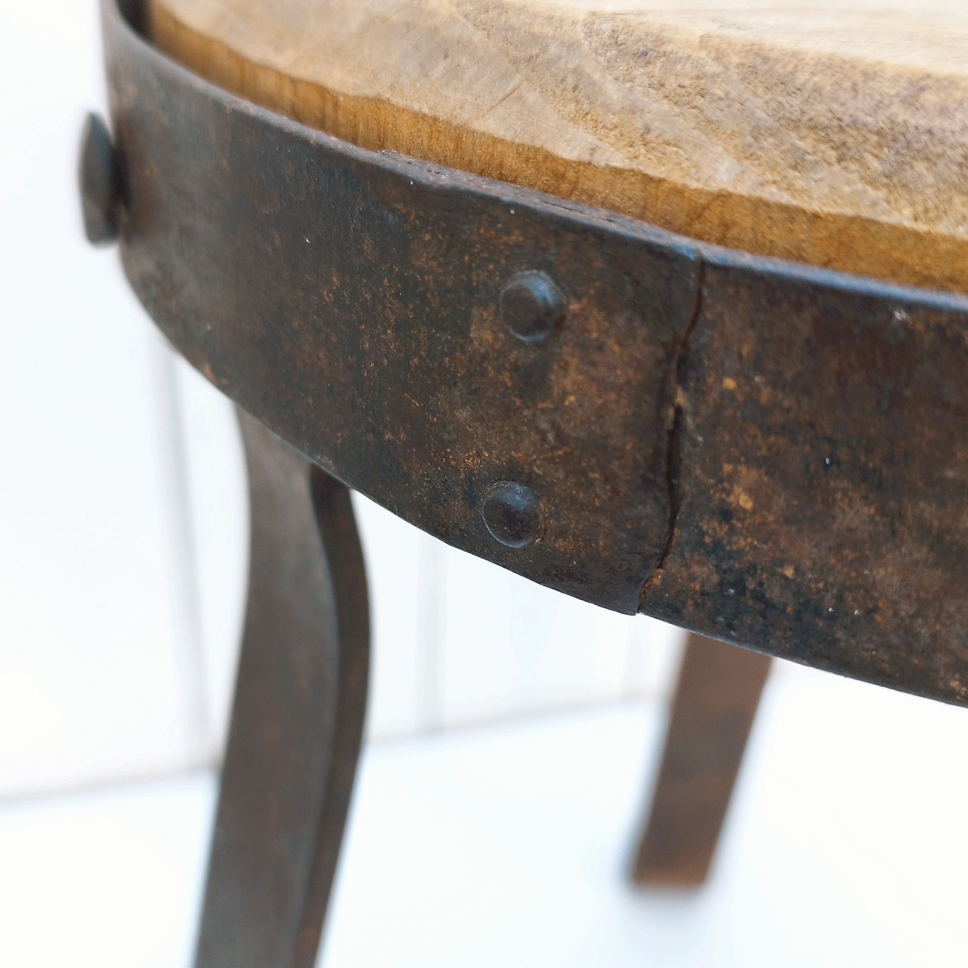 Petit tabouret brutaliste avec assise en bois patiné, cerclage  et pieds en fer forgé. Décoration très campagne ou très Loft. Patine d'origine. Un boulon a été changé. Bon état général. Hauteur : 38 cm Diamètre : 27 cm