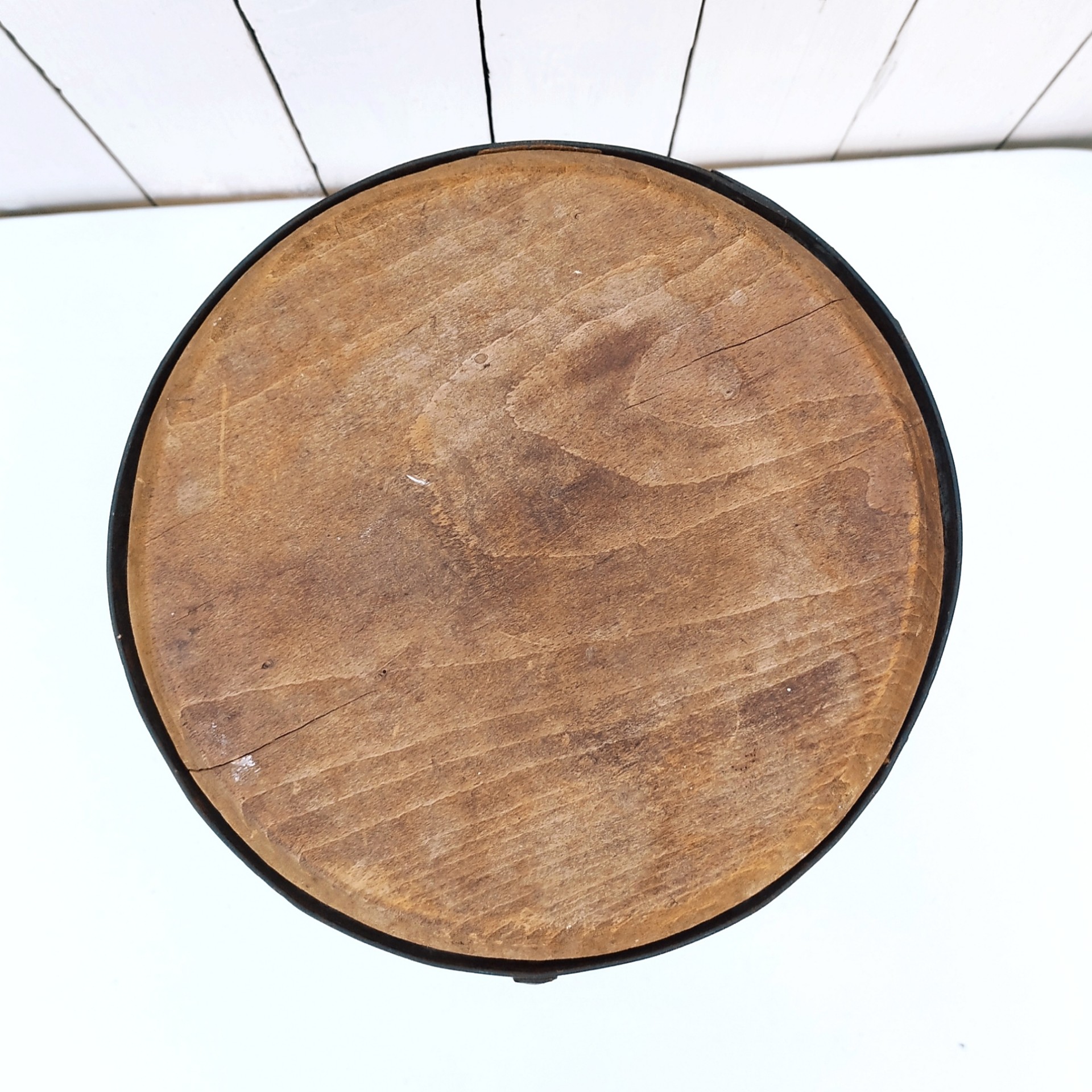 Petit tabouret brutaliste avec assise en bois patiné, cerclage  et pieds en fer forgé. Décoration très campagne ou très Loft. Patine d'origine. Un boulon a été changé. Bon état général. Hauteur : 38 cm Diamètre : 27 cm