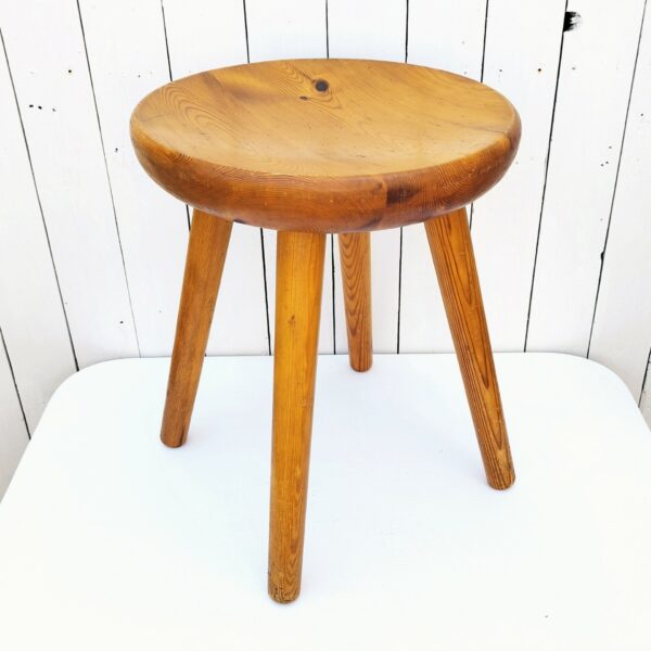 Tabouret vintage quadripode en pin. Assise creusée lui conférant un bon confort. Très belle patine du bois. Tabouret faisant penser au travail de Charlotte Perriand Traces et rayures d'usage. Bon état général. Hauteur : 46,5 cm Diamètre : 36,5 cm