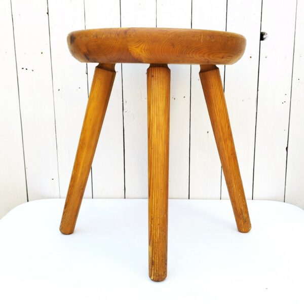 Tabouret vintage quadripode en pin. Assise creusée lui conférant un bon confort. Très belle patine du bois. Tabouret faisant penser au travail de Charlotte Perriand Traces et rayures d'usage. Bon état général. Hauteur : 46,5 cm Diamètre : 36,5 cm