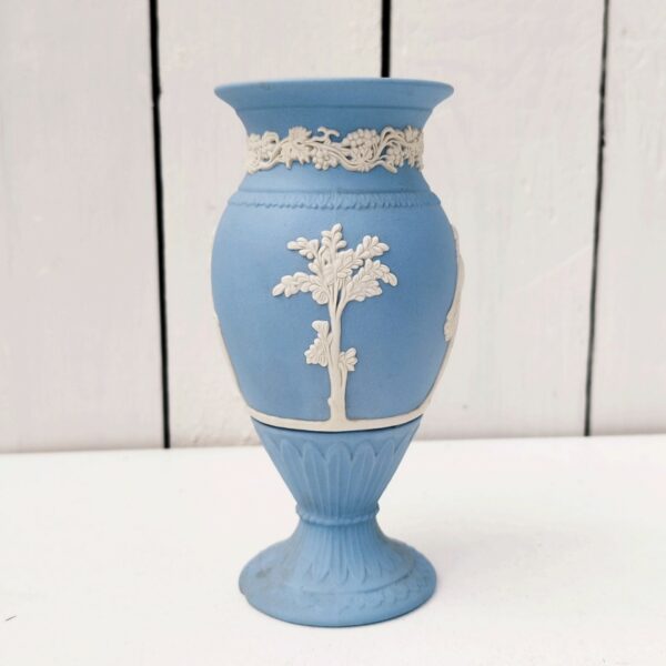 Vase en biscuit bleu et blanc signé Wedgwood, manufacture anglaise. Avec un décor de personnages à l'antique donnant l'impression d'un camée. Un petit éclat au pied. Hauteur : 14,5 cm