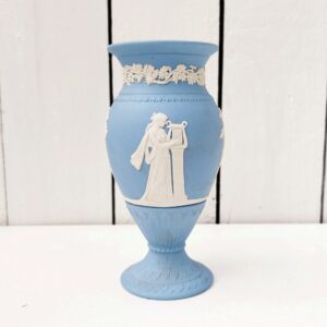 Vase en biscuit bleu et blanc signé Wedgwood, manufacture anglaise. Avec un décor de personnages à l'antique donnant l'impression d'un camée. Un petit éclat au pied. Hauteur : 14,5 cm