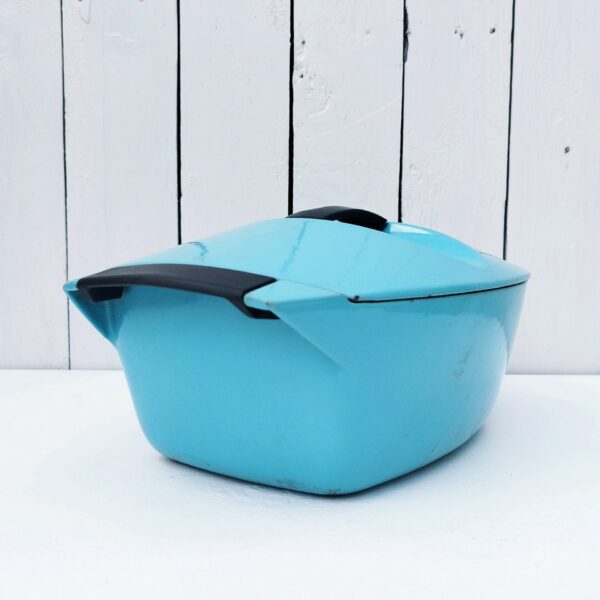 Cocotte en fonte émaillée de couleur turquoise datant des années 50, dessinée par Raymond Loewy pour Le Creuset. Contenance de 3,5 litres. Poignée du couvercle en bakélite. Des petits éclats sur le contour du couvercle. Une petite fêlure sur une poignée sans gravité. Bon état général. Longueur avec poignées : 32,5 cm Longueur sans poignées : 26 cm Largeur : 20,5 cm Hauteur : 10 cm