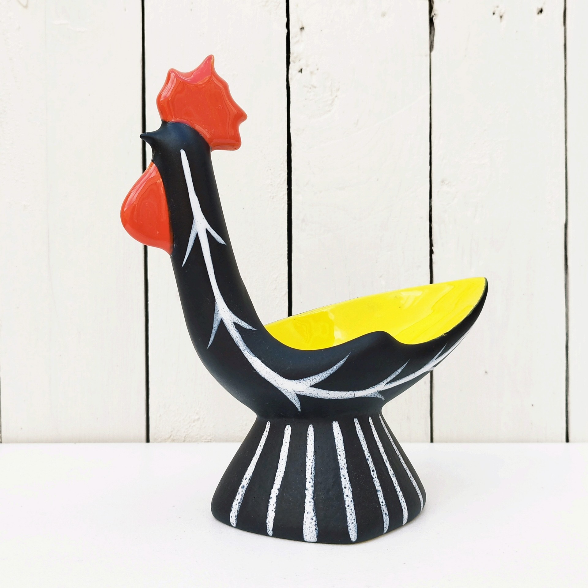 Vide poche en céramique antropomorphe représentant un coq, datant des années 50. Une micro égrenure sur le haut de la crête. Très bon état. Hauteur : 22 cm Dimensions : 19,5 x  9 cm