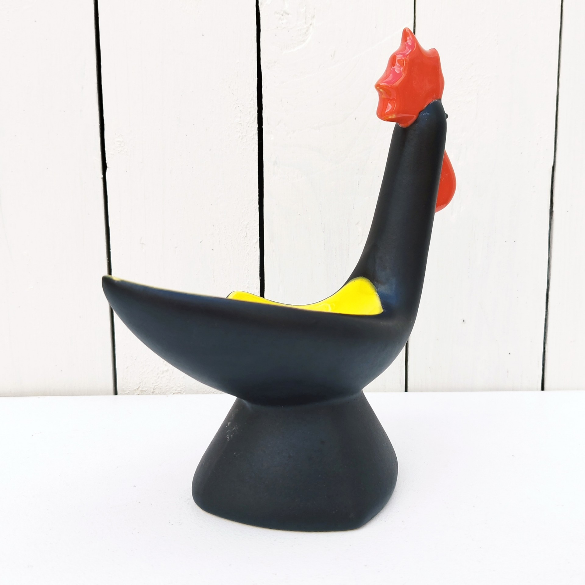Vide poche en céramique antropomorphe représentant un coq, datant des années 50. Une micro égrenure sur le haut de la crête. Très bon état. Hauteur : 22 cm Dimensions : 19,5 x  9 cm